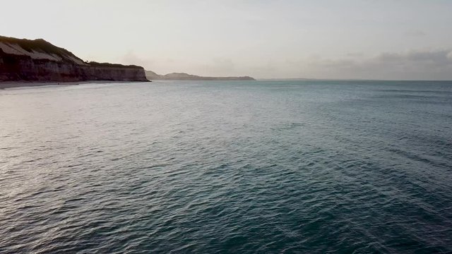 Drone footage. View from above, flying over the beach. Sun over the cliff. Coastline of Praia da pipa, Rio grande do norte, brazil.