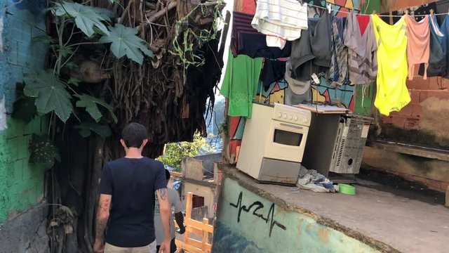 POV footage. Two man Walking inside a favela. Colourful wall. People Exploring a favela in Rio de Janeiro, Brazil