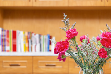 beautiful carnations inside a room with books