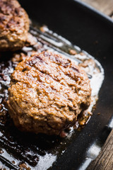 Grilled burger meat on frying pan. Selecive focus.