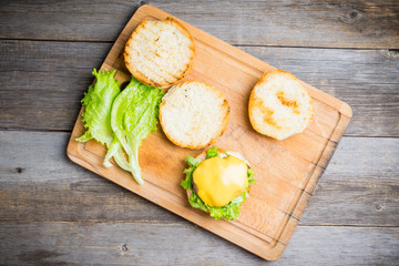 Making burger with fresh buns, meat and salad. Selective focus.