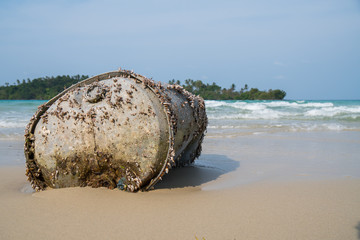 Old Tank with Sea barnacle on the beach with ocean blu sky background