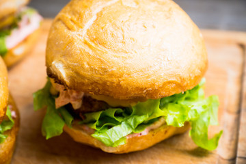 Tasty burger with fresh buns, meat and salad. Selective focus.