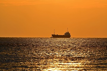 夕暮れに染まる海と船のコラボ