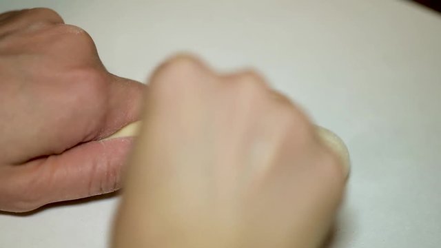 Girl hands polishing parts for making dolls from polymeric material.
