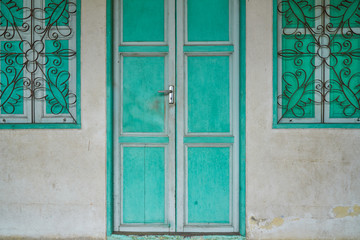 ancient retro old green wood door with vintage village