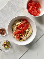 Oatmeal porridge on almond milk with grapefruit and pistachios
