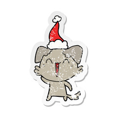 waving little dog distressed sticker cartoon of a wearing santa hat