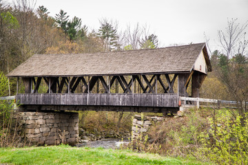 An old, weathered, wooden, covered bridge in the countryside