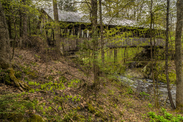 An old, weathered, wooden, covered bridge in the countryside