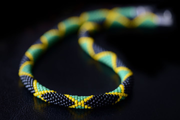 Beaded jamaican style necklace on a dark background close up