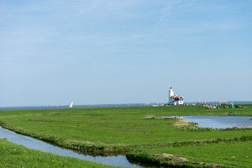 Fototapeta na wymiar Netherlands,Wetlands,Maarken, a lush green field next to a body of water