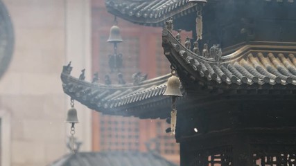 Immortal and beasts on the eaves of the building in Shanghai Jingan temple, Imperial yellow roof decorations, Wind bells under eaves sway with the wind, 4K video, slow motion. 