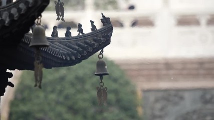 Immortal and beasts on the eaves of the building in Shanghai Jingan temple, Imperial yellow roof decorations, Wind bells under eaves sway with the wind, 4K video, slow motion. 