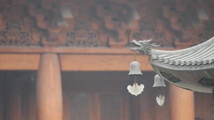 Immortal and beasts on the eaves of the building in Shanghai Jingan temple, Imperial yellow roof decorations, Wind bells under eaves sway with the wind, 4K video, slow motion. 