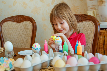 The girl is fun painting eggs for Easter