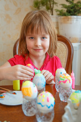 The girl is fun painting eggs for Easter