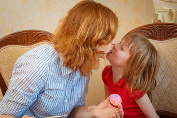 Mom and daughter have fun painting eggs for Easter.