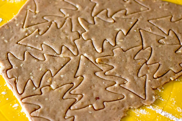 Fototapeta na wymiar Christmas cookies new year tree. Chocolate dough rolled into a thin layer and herringbone metal molds for cutting cookies on it. Festive new year food preparation concept