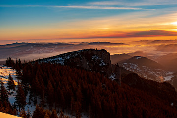 Mountain landscape with winter fog at sunse of Ceahlau, Romaniat