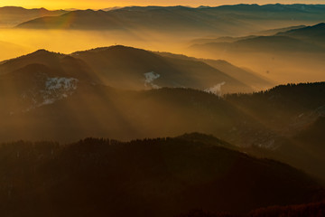 Mountain landscape with winter fog at sunse of Ceahlau, Romaniat
