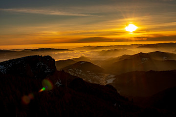 Mountain landscape with winter fog at sunse of Ceahlau, Romaniat