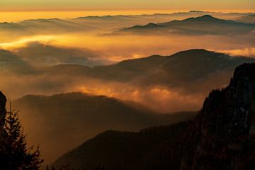 Mountain landscape with winter fog at sunse of Ceahlau, Romaniat