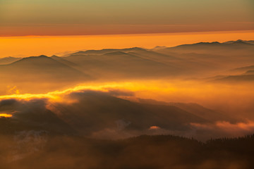 Fototapeta na wymiar Mountain landscape with winter fog at sunse of Ceahlau, Romaniat