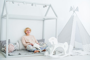 A senior woman sit on a floor in the nursery room