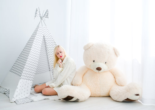 Woman sitting on a floor with a toy teddy