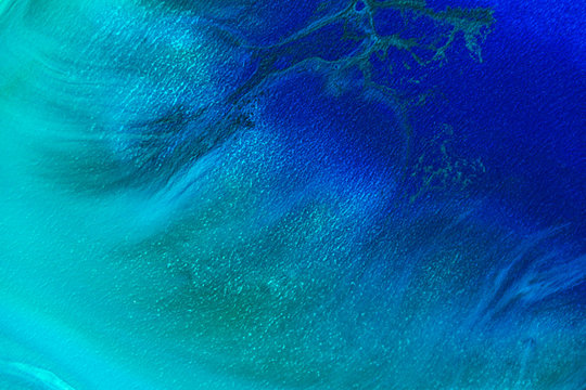 Abstract painting drawn by fluid acrylic technique. Picture with blue, green, emerald, colorful water stains, gradients on dark background. Imitation of northern lights on canvas. Modern art concept.