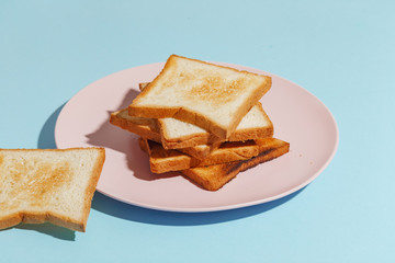 Plate with toasted bread on light-blue background.
