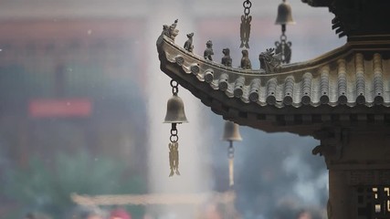 Immortal and beasts on the eaves of the building in Shanghai Jingan temple, Imperial yellow roof decorations, Wind bells under eaves sway with the wind, high speed video, slow motion. 