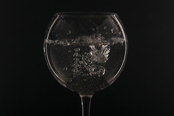 A glass with water at dark background