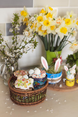 Easter sweets and decorations eggs with funny bunny on kitchen table