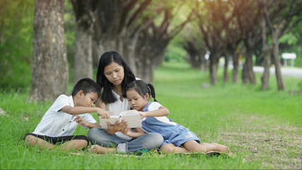 Happy family, Mother daughter and son joint a activities by read book in garden.