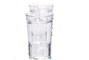 two glasses, shot glasses with liquid on a white background