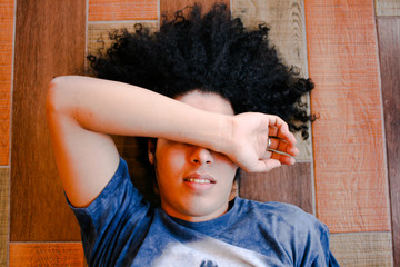 Boy smiling with his arm over his face