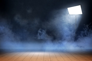 Room with wooden floor and smoke with light from spotlights