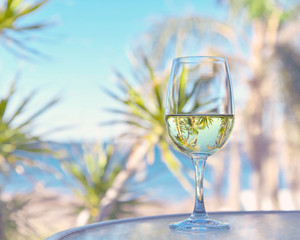 glass of white wine with ocean beach view