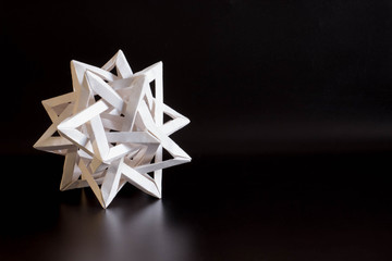 tetrahedron made of white paper on black background