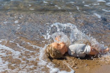 Old Doll Washing Ashore on a Mediterranean Beach