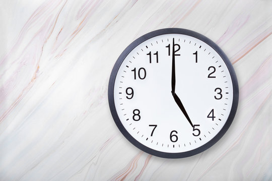Wall clock show five o'clock on marble texture. Office clock show 5pm or 5am on marble texture with natural pattern