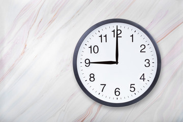 Wall clock show nine o'clock on marble texture. Office clock show 9pm or 9am on marble texture with...