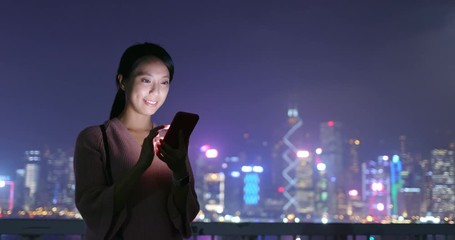 Woman send sms on cellphone in Hong Kong at night
