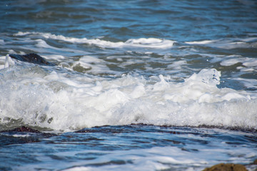 Sea wave foam on the beach in Estepona, Andalucia, Spain. Peaceful ocean waves at beach.