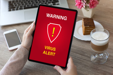 woman hands holding tablet computer with warning virus alert alarm