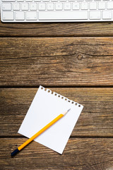 place of work, white note paper, pencil, keypad, old wooden table background