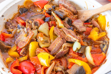 Stew with pork, eggplants, tomatoes and multicolored peppers close-up
