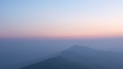 Stunning Winter sunrise landscape image of The Great Ridge in the Peak District in England with mist hanging around the peaks